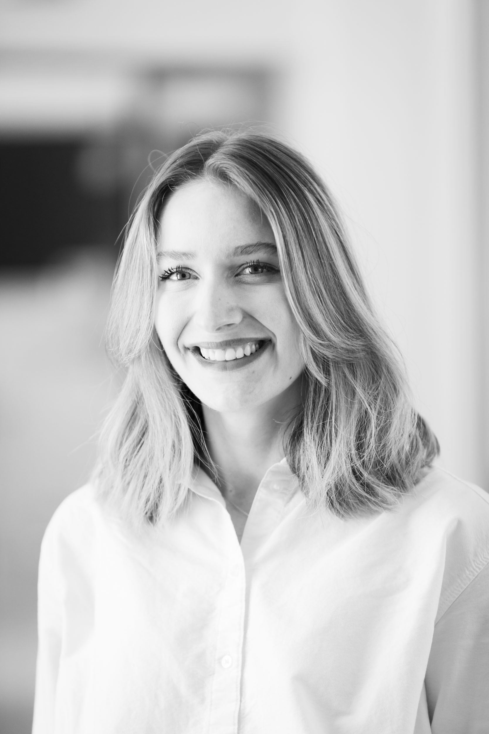 Portrait de profil pour les réseaux sociaux en noir et blanc d'une femme sur fond flou réalisée par un photographe portraitiste professionnel