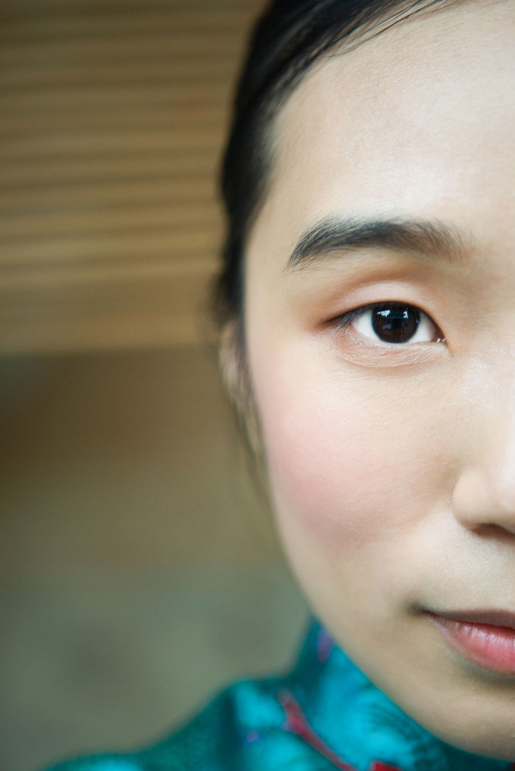 Portrait artistique d'un demi visage en très gros plan d'une femme asiatique qui regarde dans l'objectif