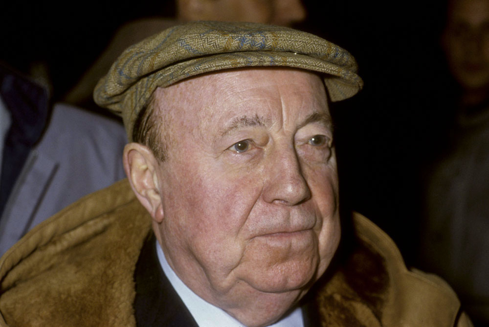 Portrait en couleur du réalisateur Marcel Carné avec une casquette sur la tête