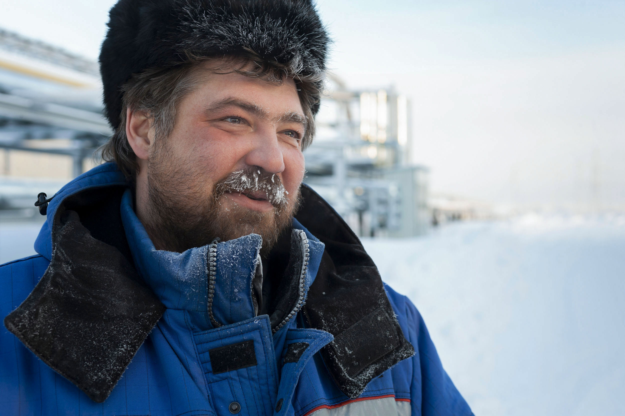 Portrait en extérieur d'un homme en chapka sur un site gazier de Gazprom en Sibérie en hiver, la température est de moins 43 degrés, sa moustache est givrée