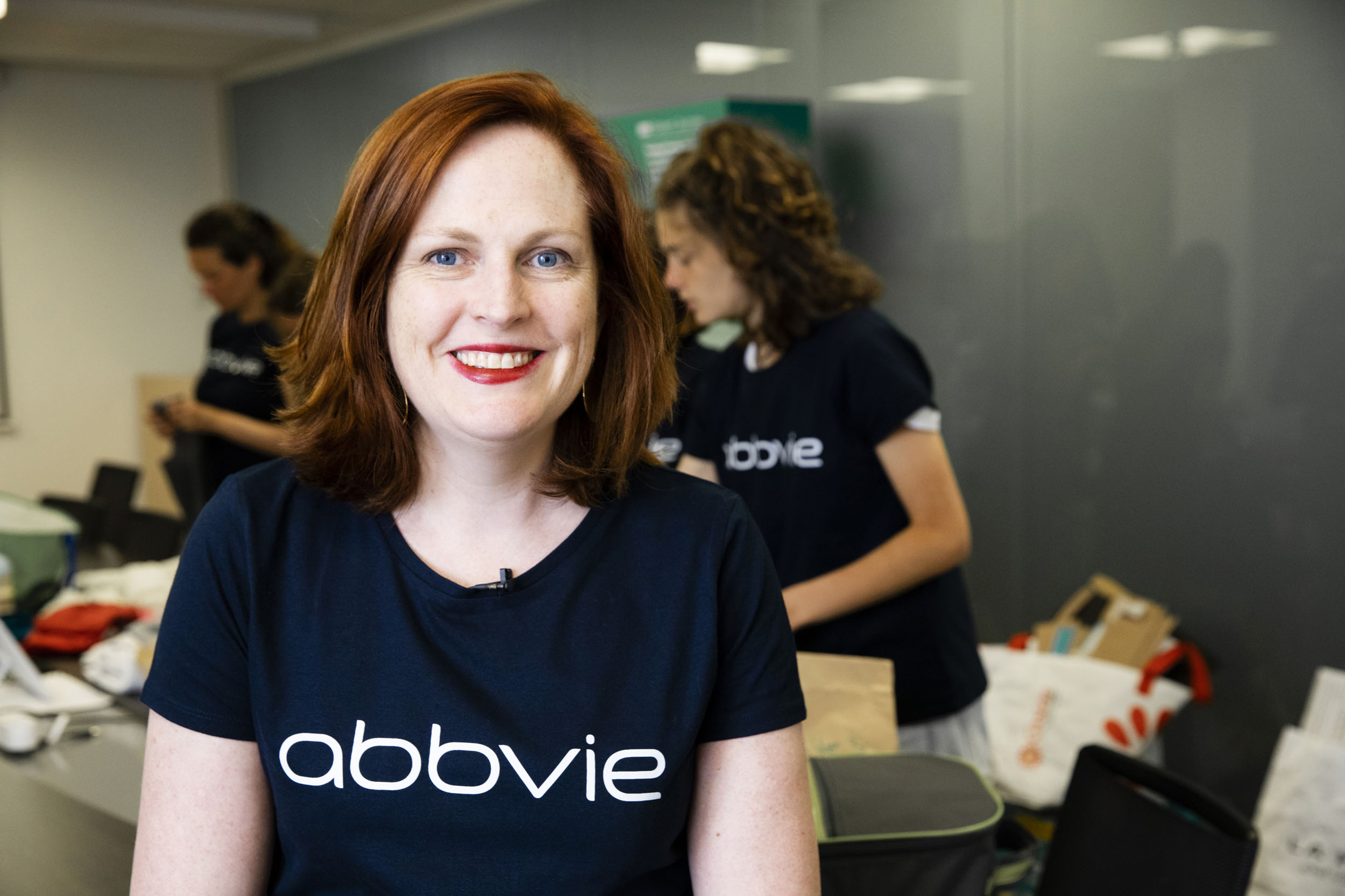 Portrait d'une femme volontaire bénévole souriante dans une salle pendant une action de soutien de l'entreprise