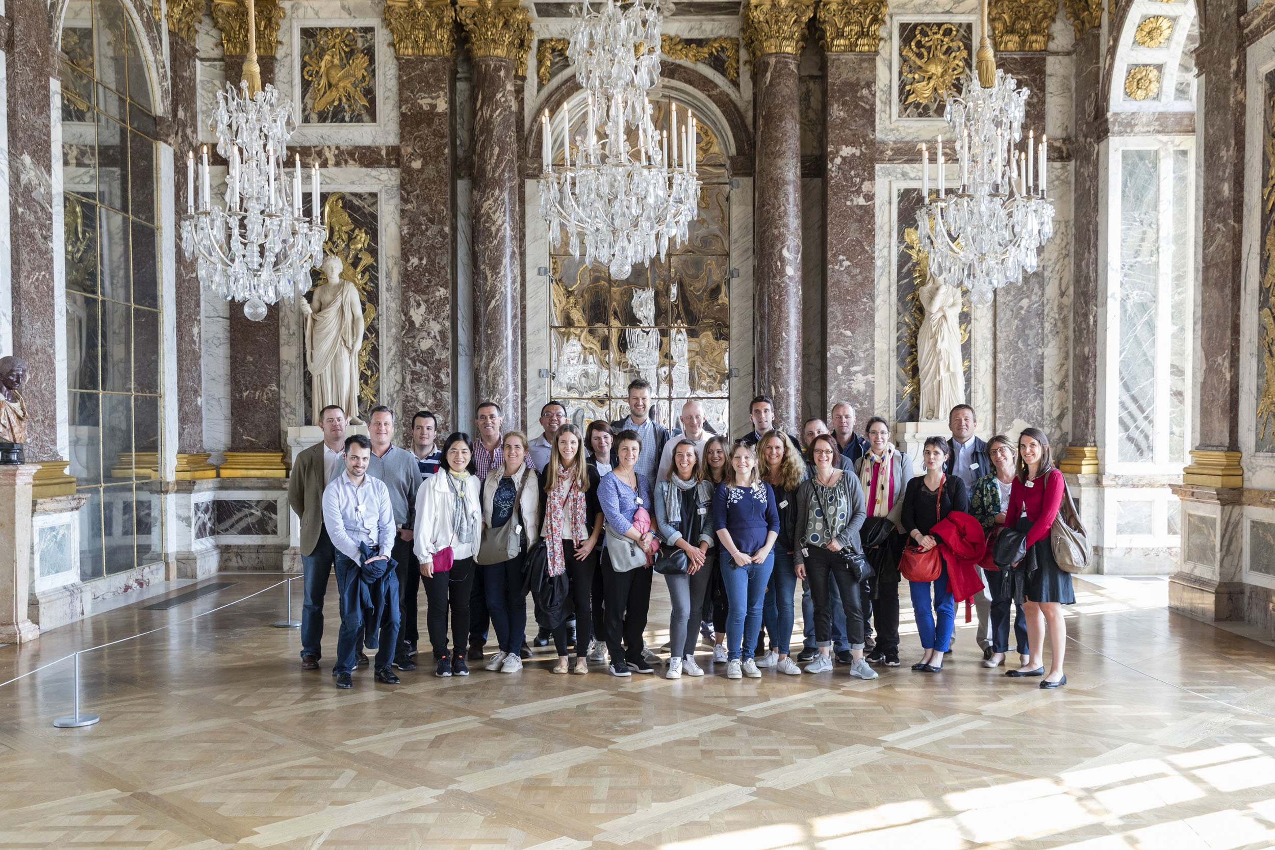 Groupe de participants à une formation de manager de l'entreprise. Portait d'un groupe de 26 personnes réalisé dans la galerie des glaces du château de Versailles