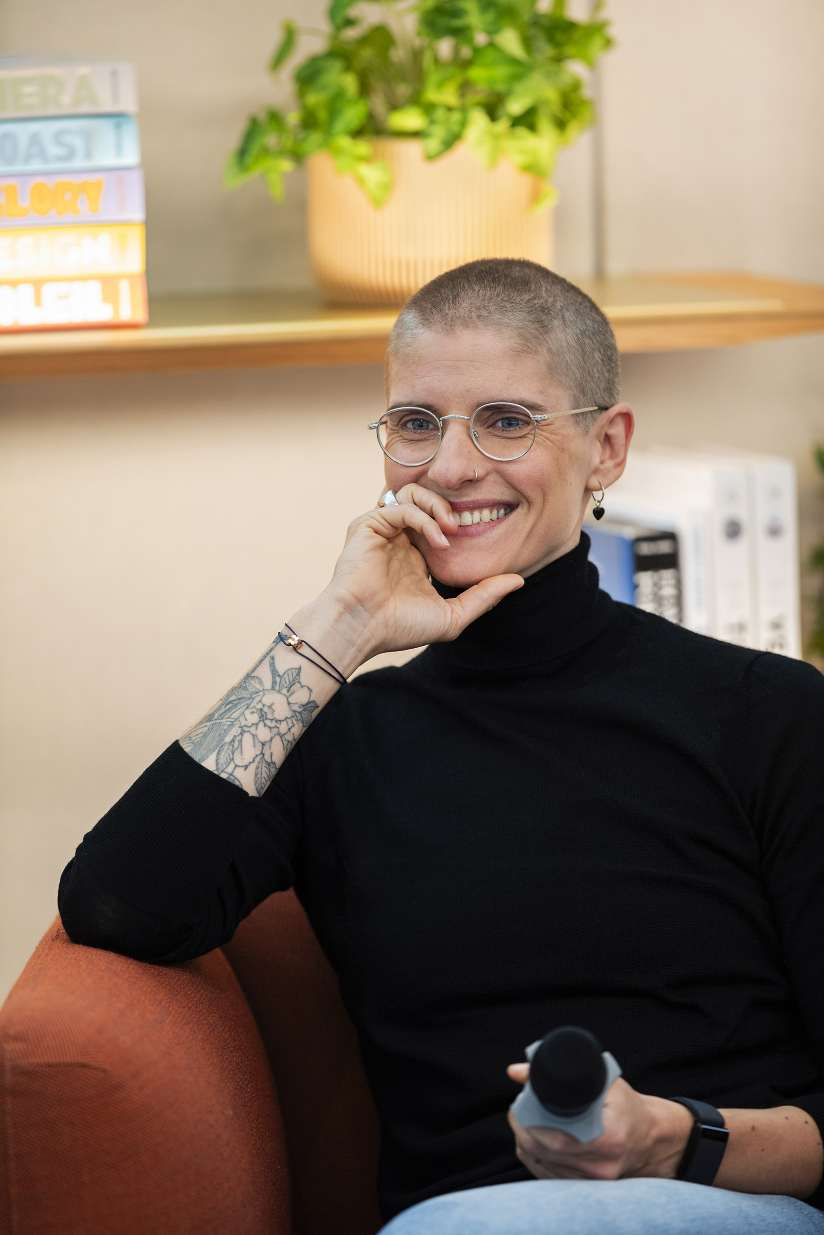 Portrait de Marie Patouillet coureuse cycliste médaillé d'or aux JOP de Paris 2024, elle est souriante, assise dans un fauteuil et tient un micro à la main