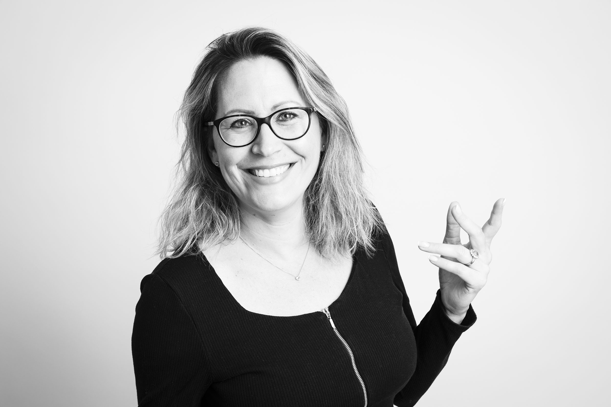 Portrait corporate en noir et blanc d'une femme souriante en mouvement.
