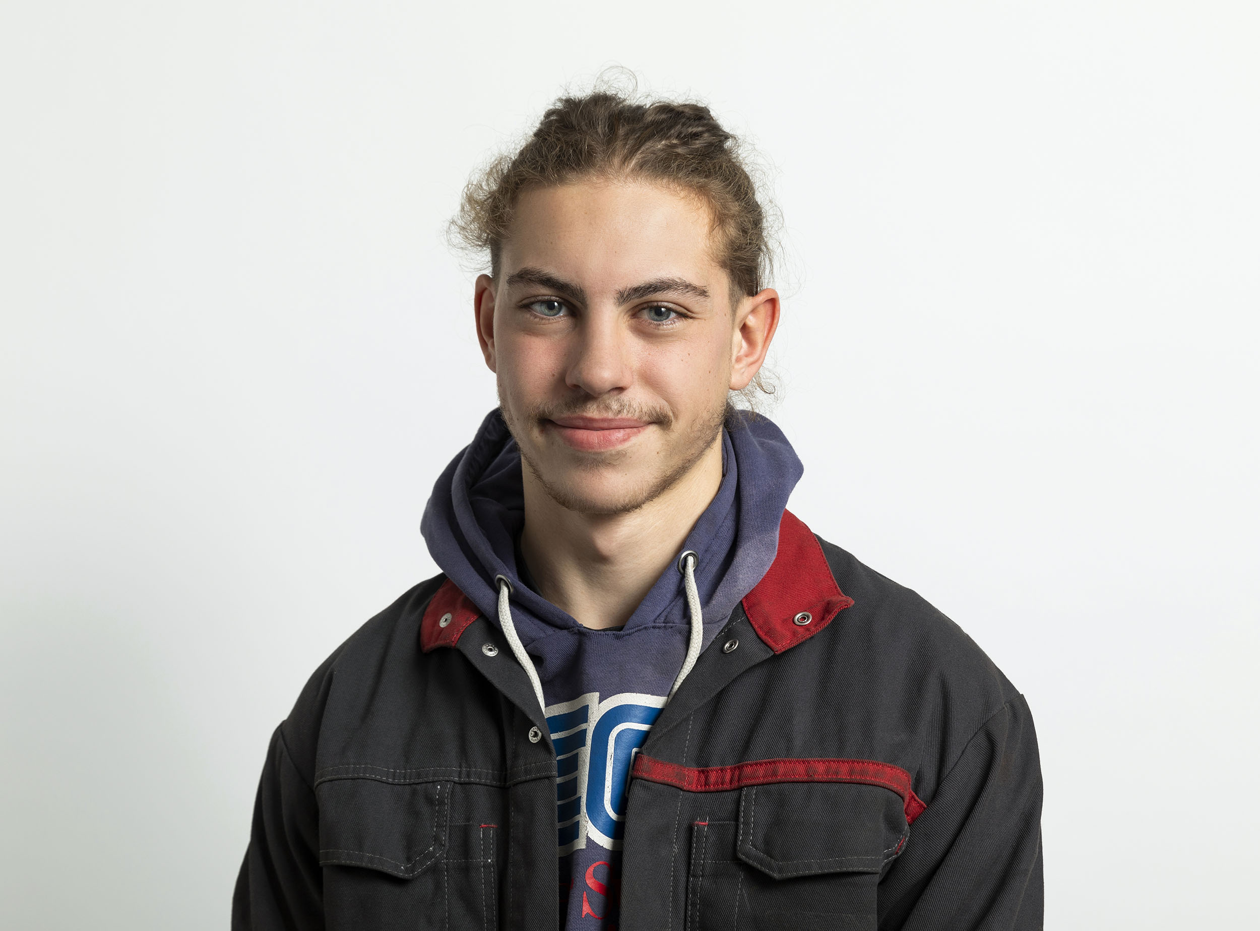 Photo de portrait en studio sur fond blanc d'un jeune homme apprenti alternant
