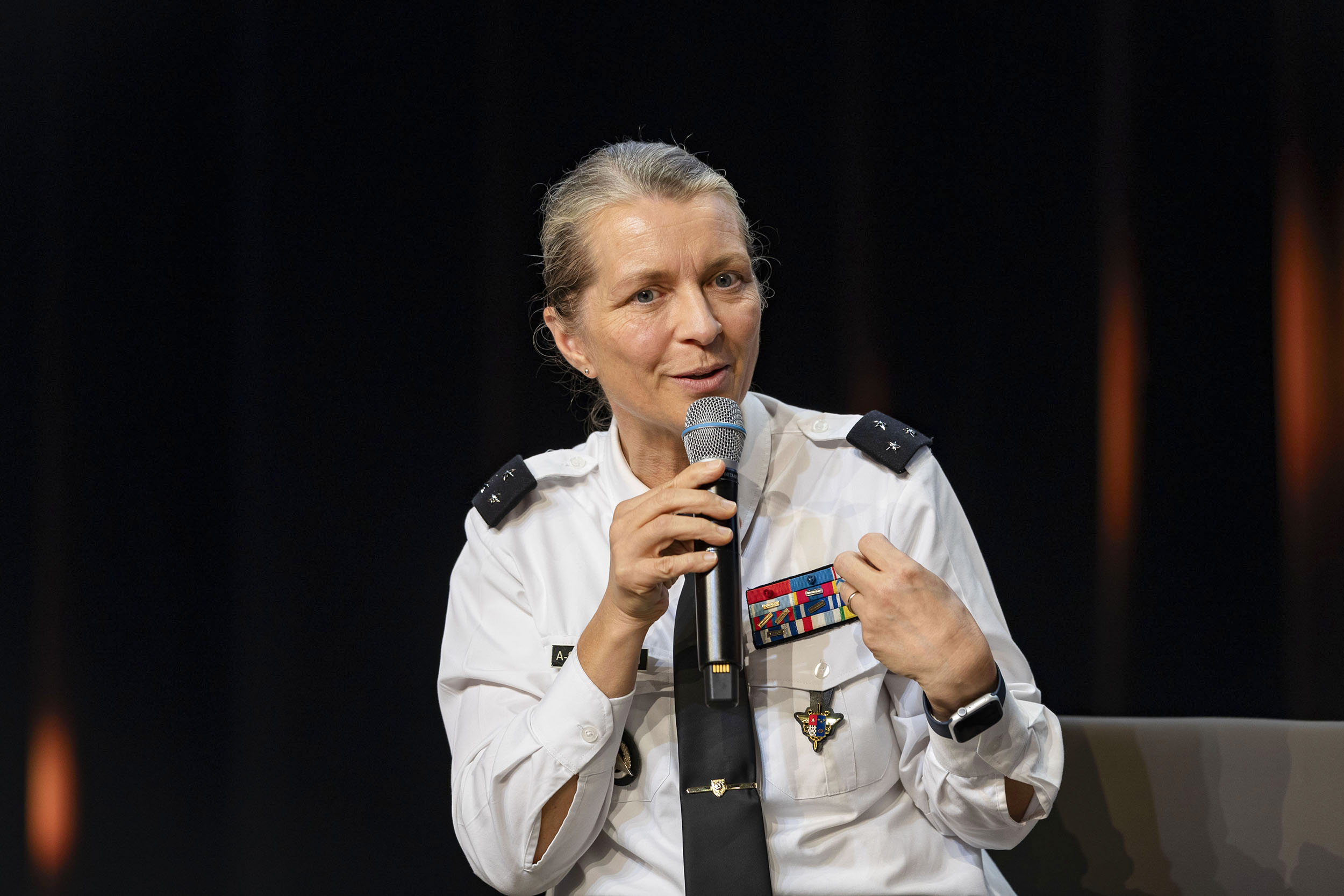 Photo de portrait d'une générale de division sur scène avec un micro à la main lors des journées de l'AND à l'École polytechnique